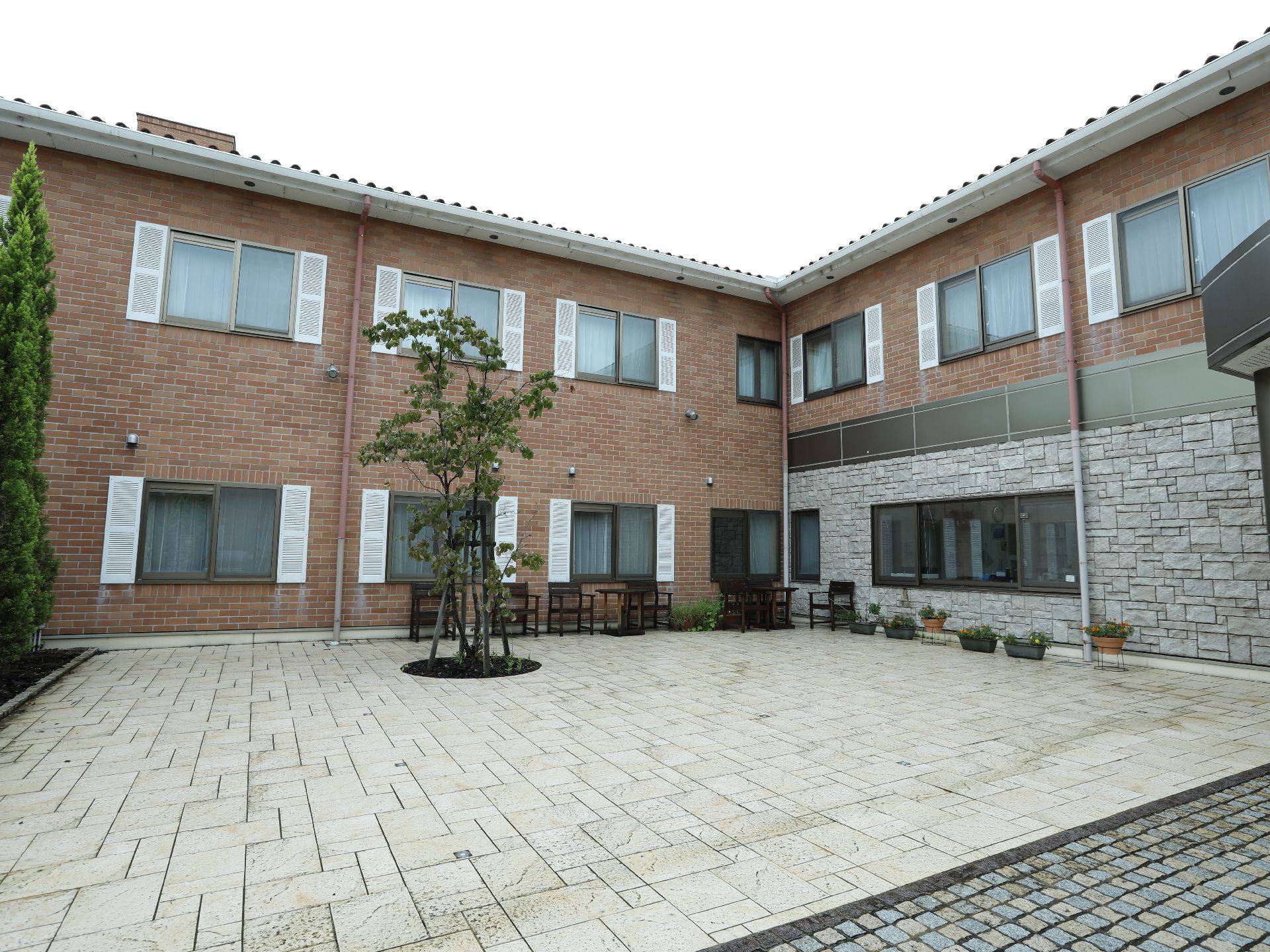 2階建ての建物となっている。入口周辺は広々としている。レンガ風のおしゃれな外観となっている。植物がたくさん植えられている。