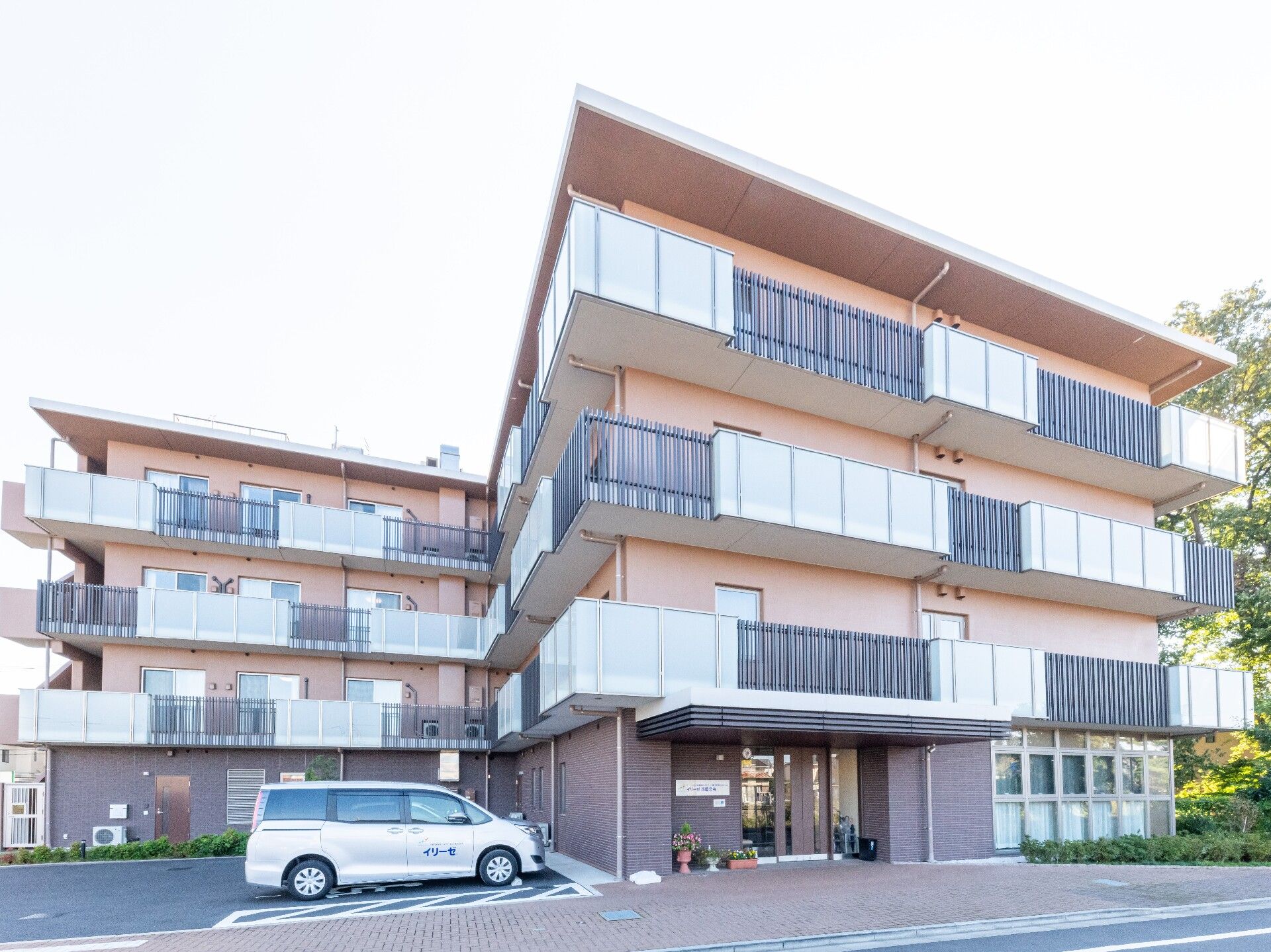 茶色を基調とした外壁のベランダが付いた4階建ての建物