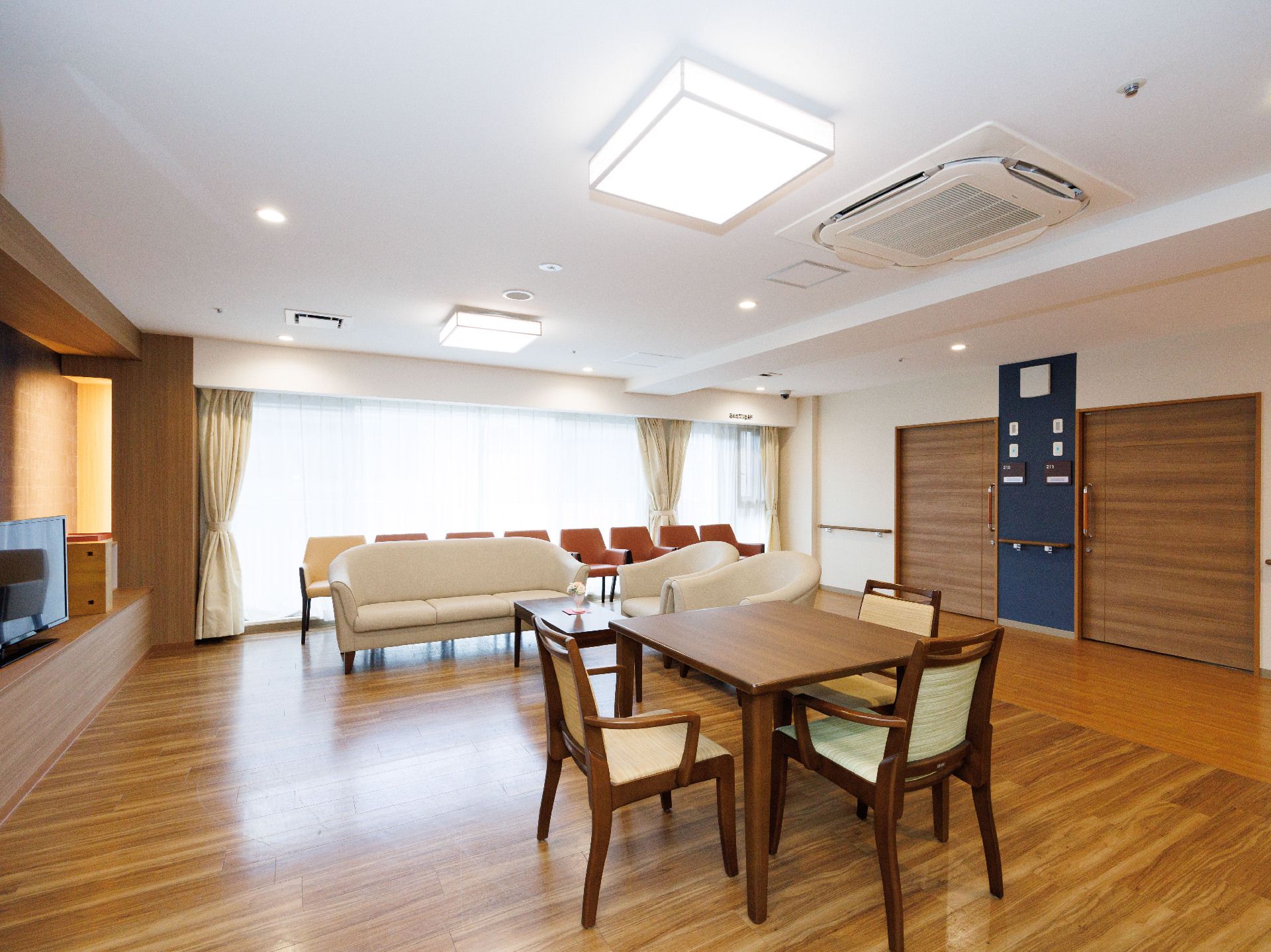 一面窓ガラスの部屋に置かれた４脚の椅子に囲まれた机