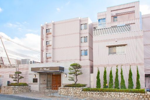 マンション風の施設外観になっており、外壁には施設名が記された看板が設置されている。手すりが備えつけられている。