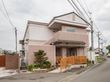 ピンク色の外壁がアットホームで、一軒家のような見た目である。周りは住宅地となっており、閑静な環境である。
