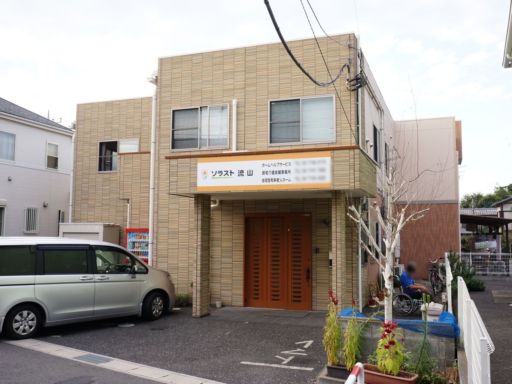 施設は2階建ての茶色い建物である。玄関前には大きな屋根があり、前面には施設名を書いた大きなプレートを設置している。