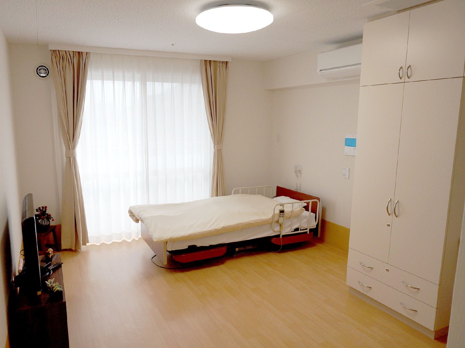 引き出しと開き扉がある衣装棚と、エアコンが設置された居室