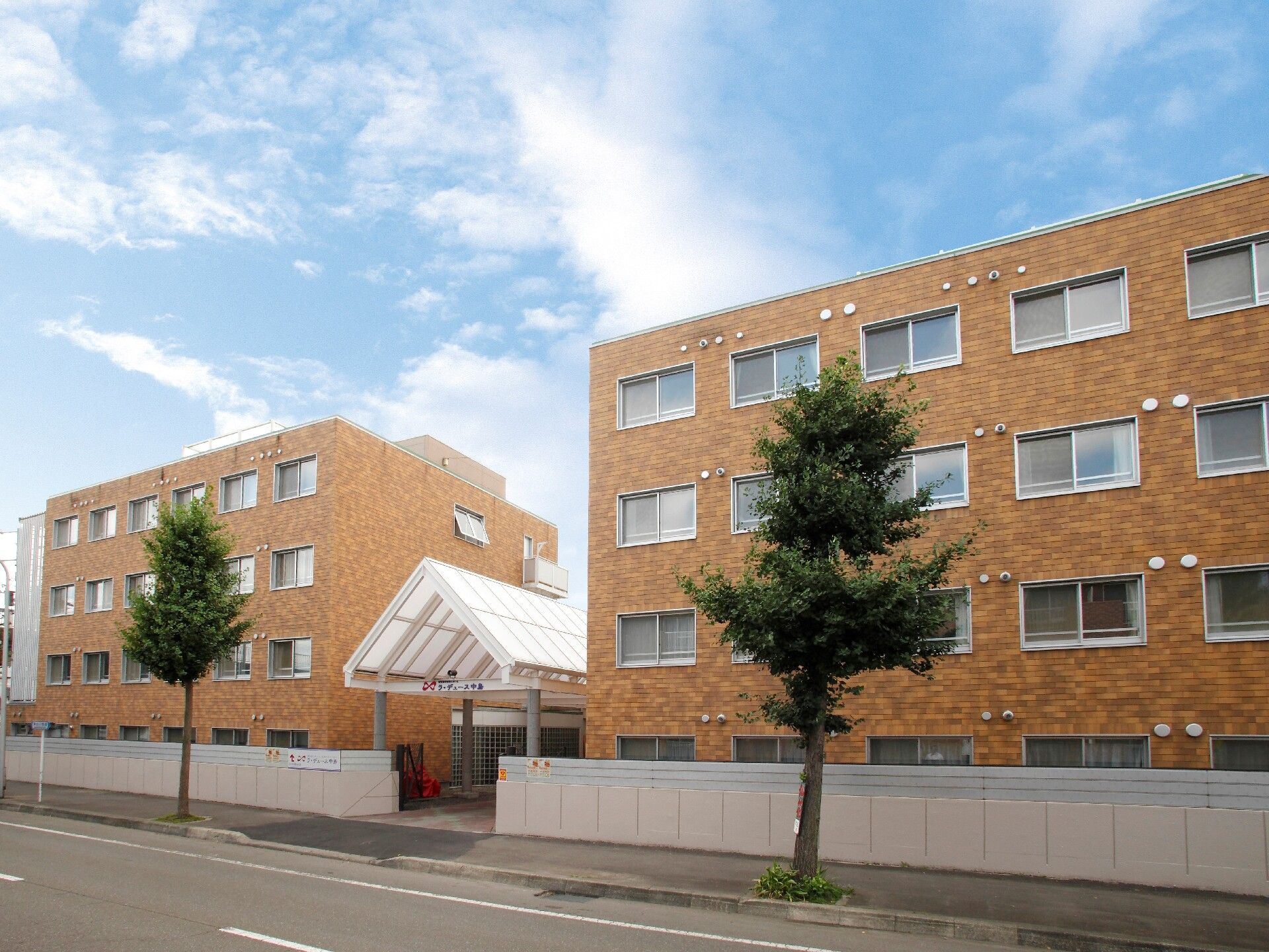 やわらかい濃い目のベージュを施した施設の外観。介護付き有料老人ホームラ・デュース中島の外観