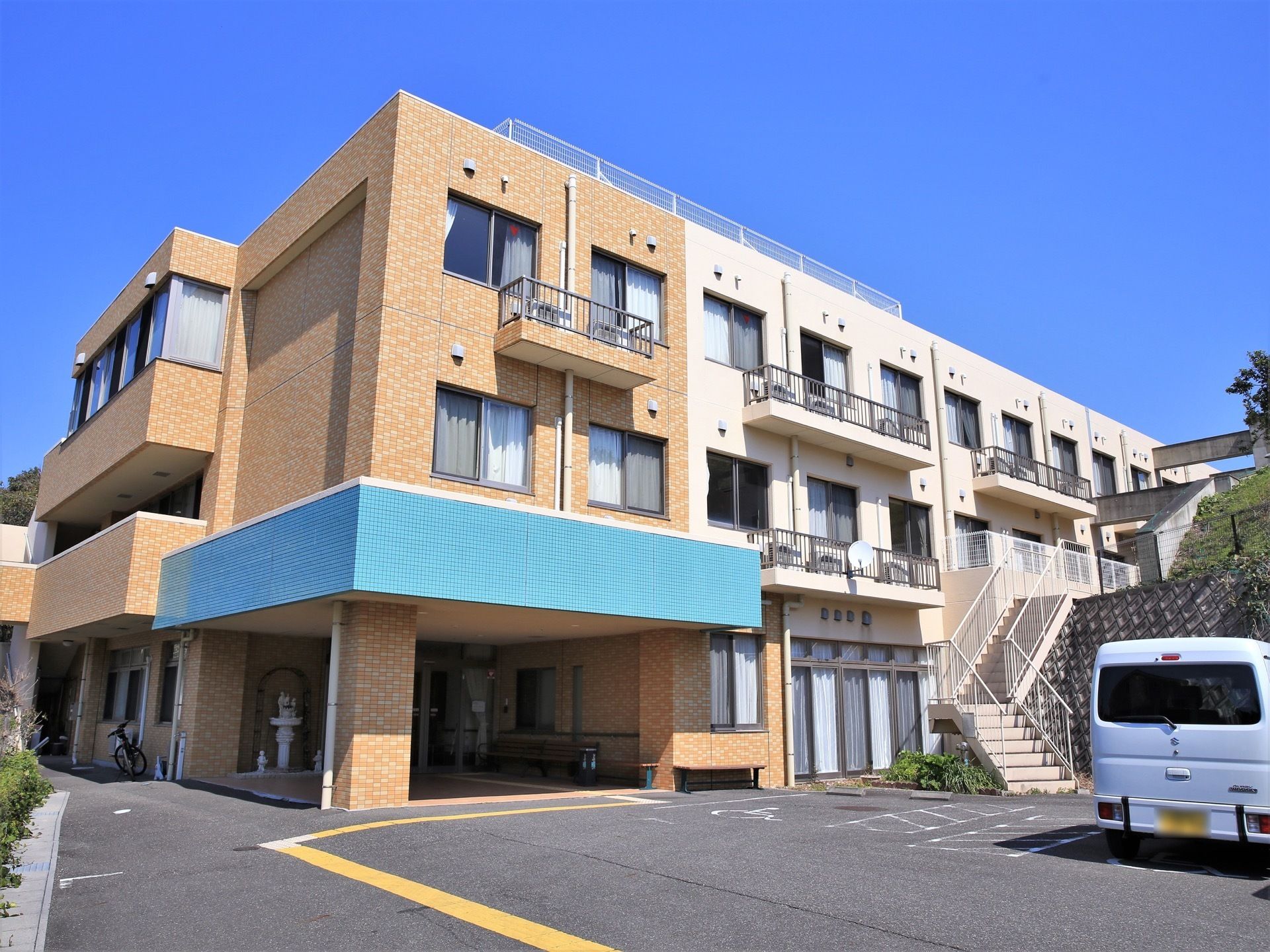施設の前にある駐車場から玄関へと続く点字ブロックが敷設されている。駐車場には車椅子をご利用の方専用のスペースも用意されている。