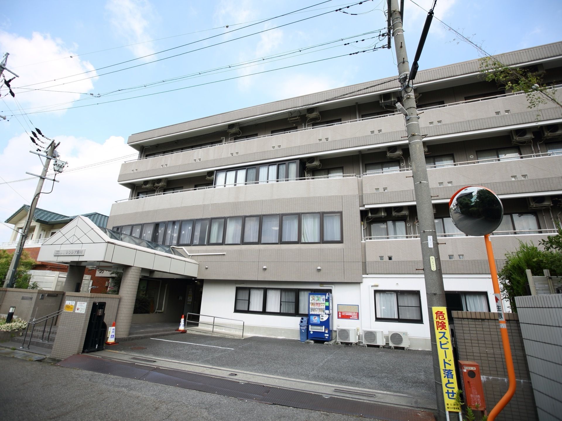 施設は閑静な住宅街に立地している。高い建物がなく、日当たりが良い。敷地内に駐車スペースが多数設置されている。