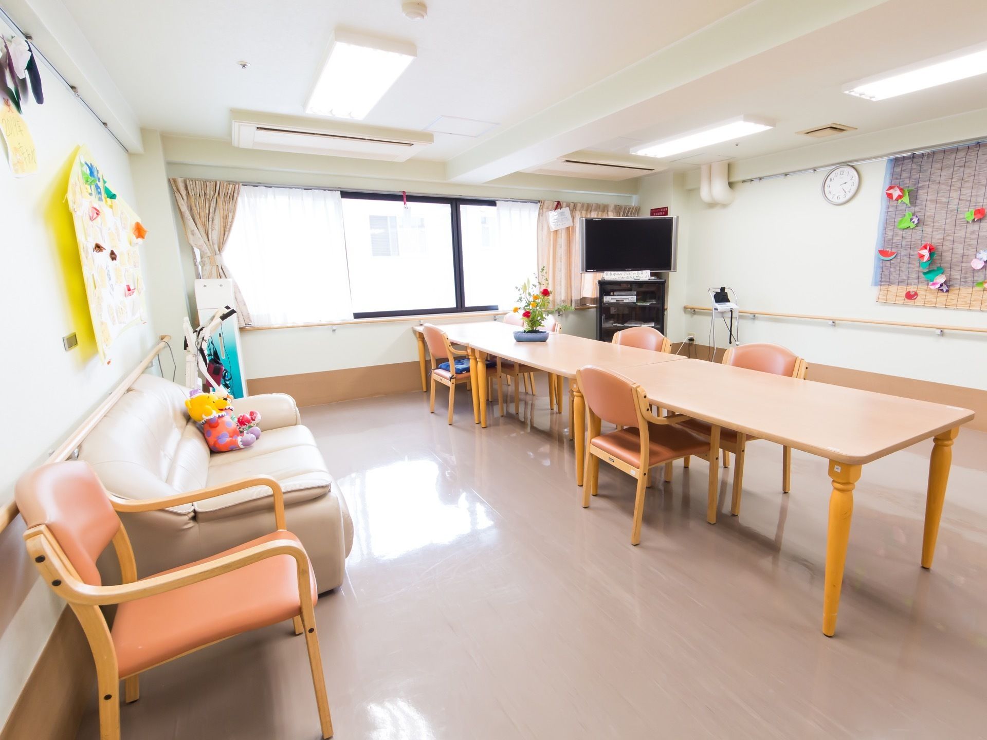 日当たりが良く、広々とした部屋の中央にテーブルが置かれている。テーブルを中心として、ソファーやテレビが囲むように配置してある。