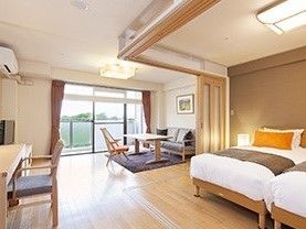 二つベッドが並べられた部屋にはソファやいす、テーブルセットが置かれた広い居室。