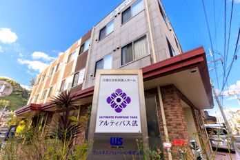 ブルーのユニフォームを着た男性スタッフが赤いロープを両手で引っ張っている高齢女性の手伝いをしている。