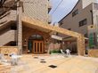 「応援家族 成増」の外観。高いマンション街に位置する、5階建てのベージュ色の建物。