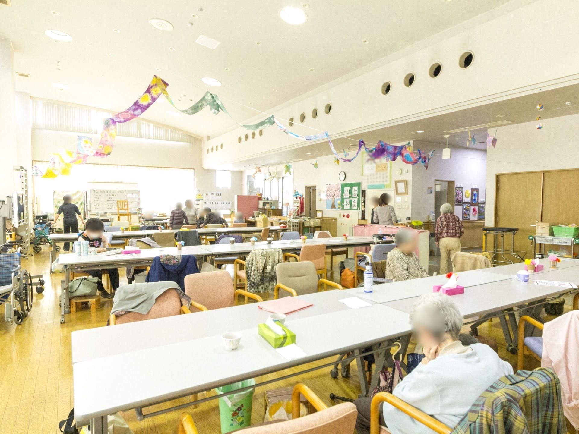 大きな窓ガラスが設置されていて、明るい日差しが入っている。ホワイトボードが置かれていて、文字などが書かれている。