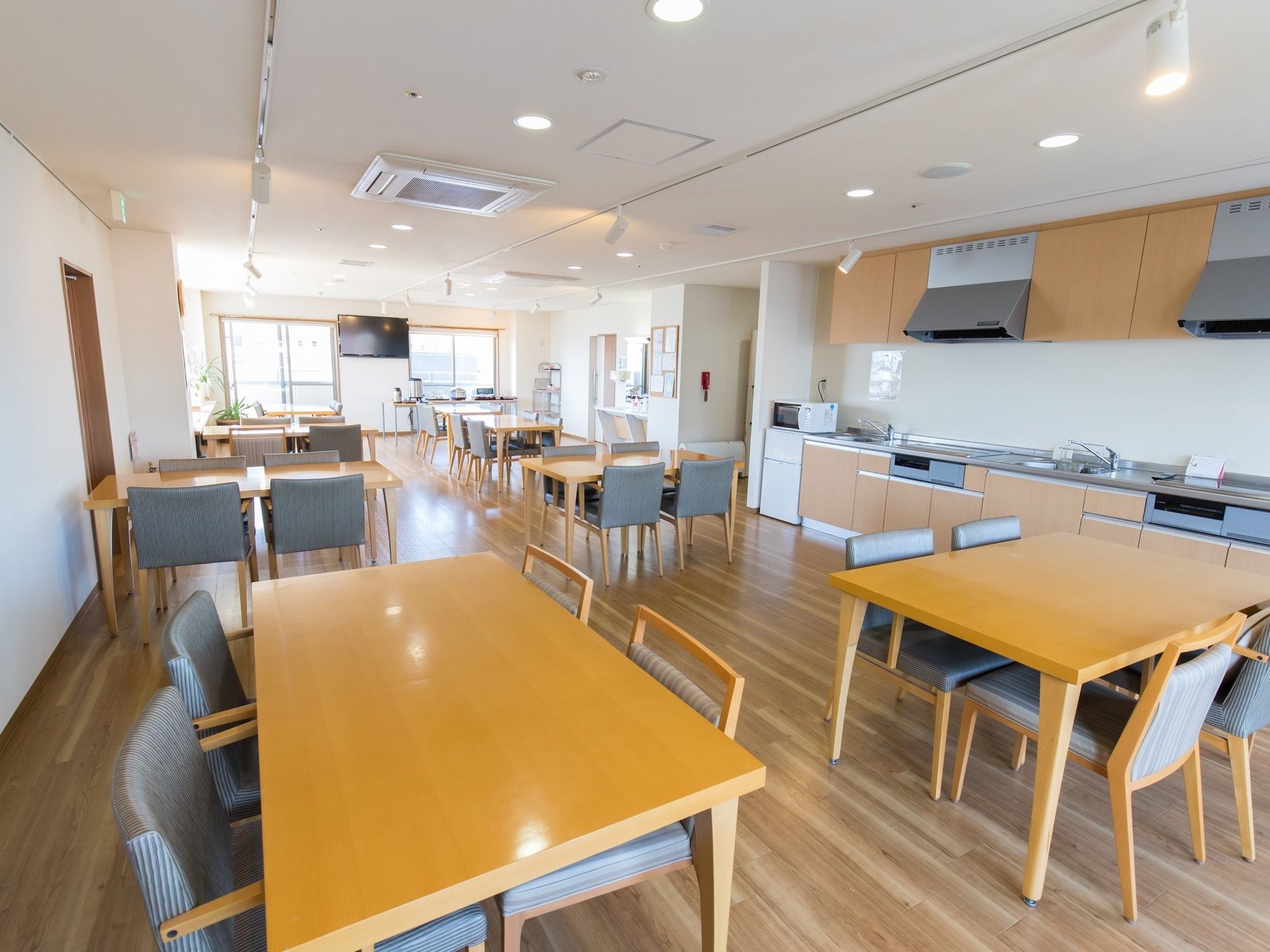 共有で利用できるキッチンを備えた食堂兼リビングルームである。壁掛けテレビを設置し、どの場所からでもテレビ観賞を楽しむことができる。