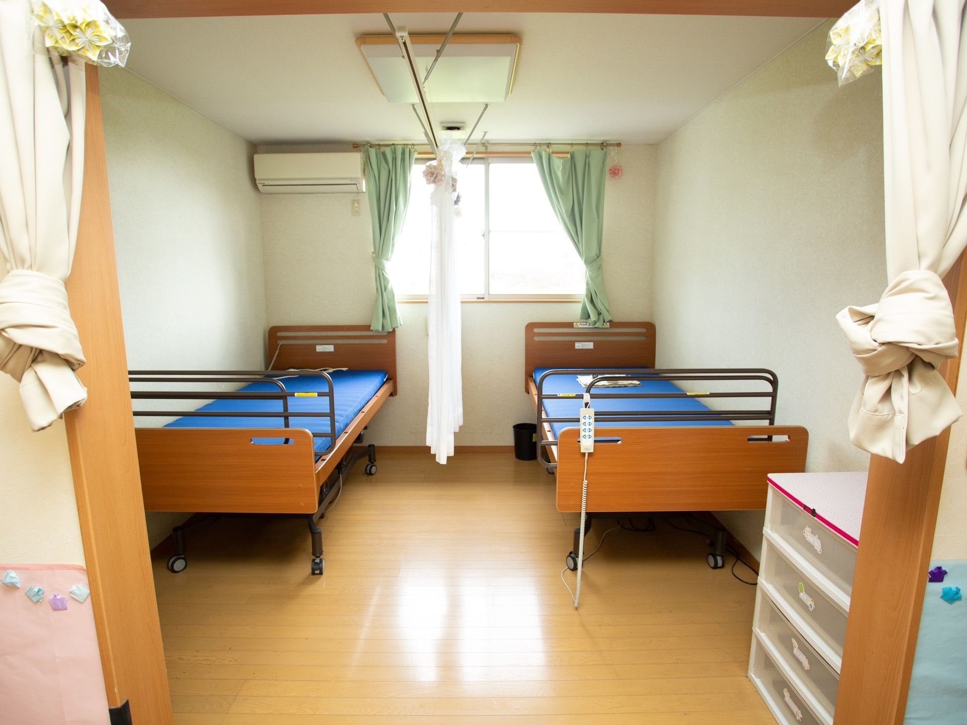 部屋の外にある白いカーテンは、まとめて上にあげている。室内にはエアコンがあり、室温の調節が可能である。