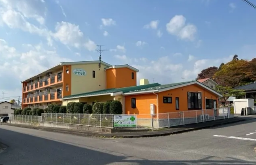 平屋と３階建ての建物が併設されており、平屋に玄関がついている。３階の建物には、非常階段が外に取りつけられている。