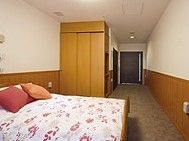 ベッドのほか、天井まで届く背が高いクローゼットがある。部屋の扉は引き戸で、取っ手が縦長で大きいので、扱いやすい。