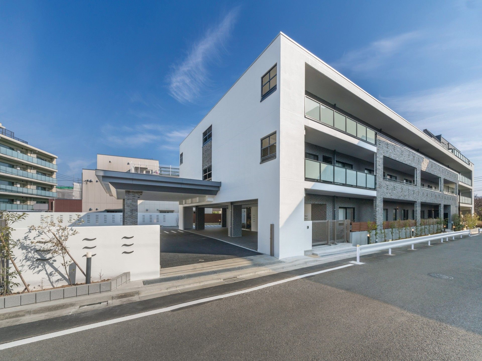 施設は白色が基調になっている外壁で3階建ての建物である。建物の前には複数台停めることができる駐車スペースがある。