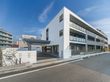 施設は白色が基調になっている外壁で３階建ての建物である。建物の前には複数台停めることができる駐車スペースがある。
