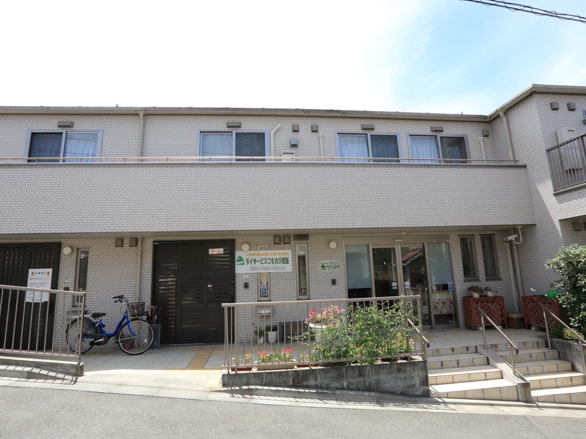 施設は横に長い2階建ての建物である。なだらかな坂道に沿って建てられており、入口前には手すり付きの階段がある。