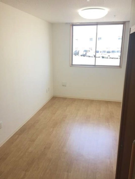 照明がある小さな部屋の一角。窓の外に小さな街並みが見えている