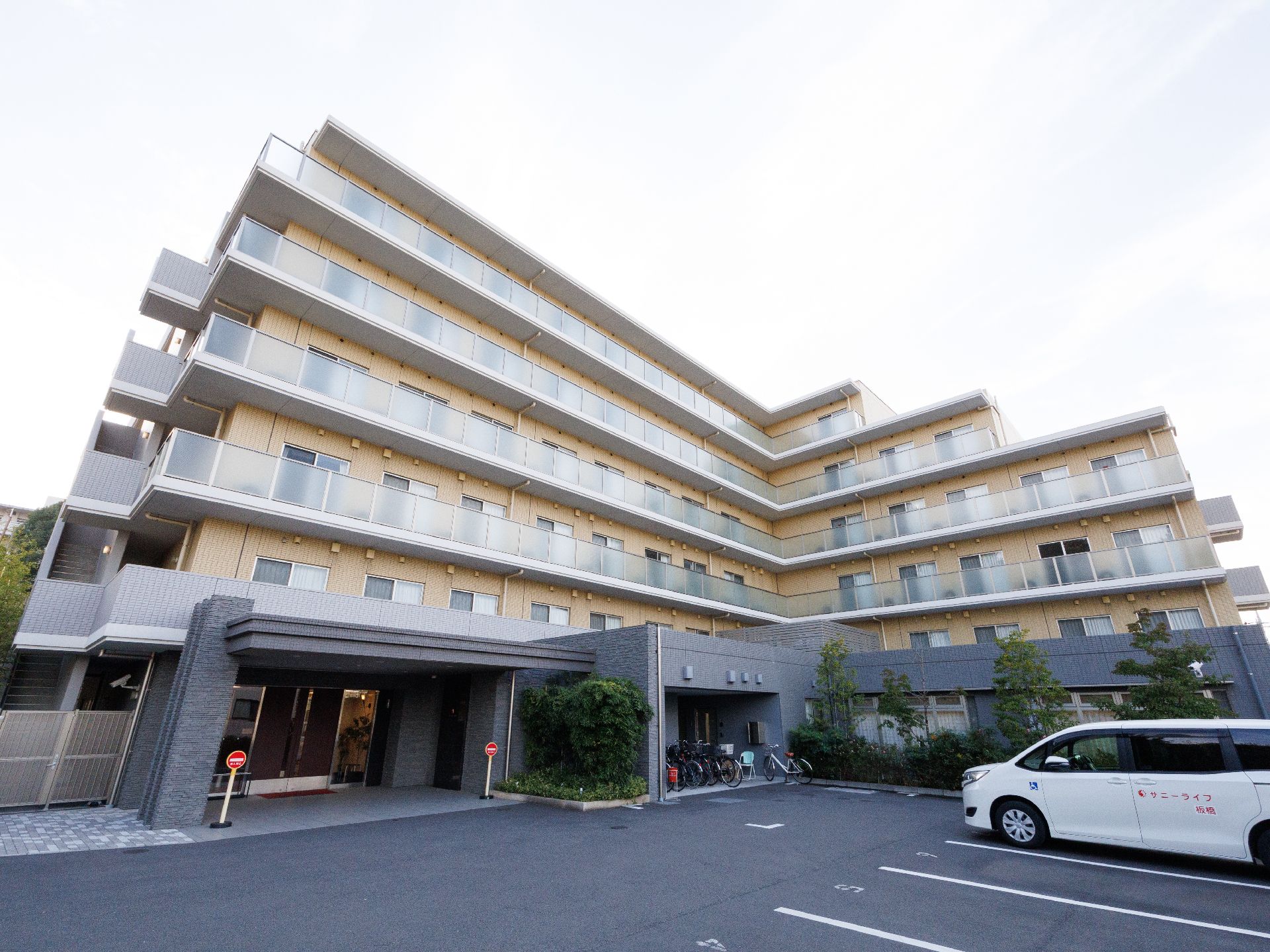 駐車場から撮影した２階建ての介護施設の外観