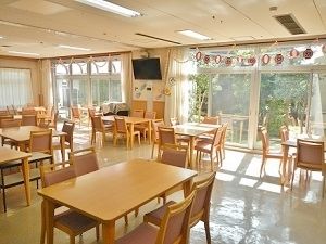 窓の間の壁にテレビが取り付けられているダイニングルーム