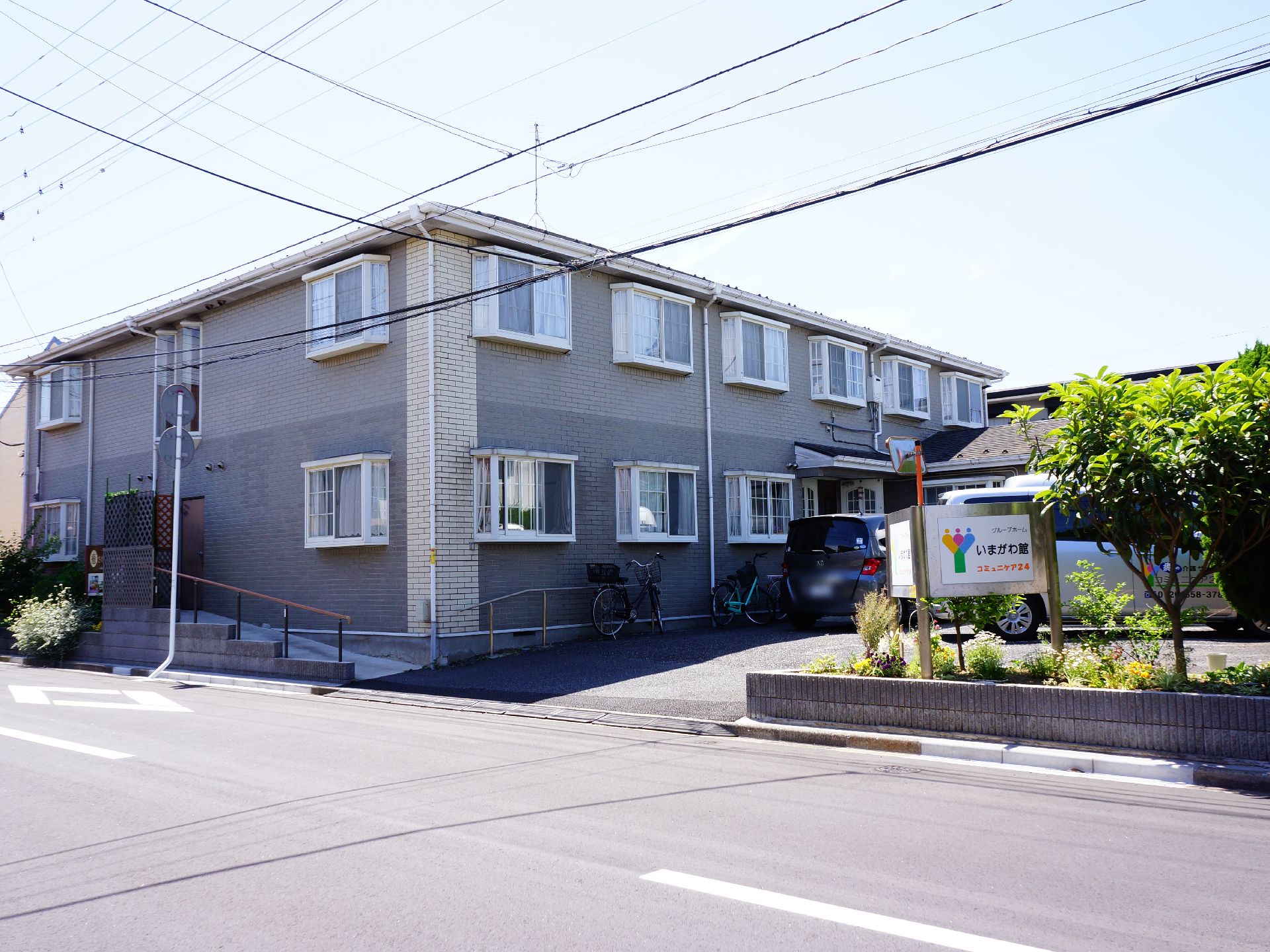 外から見ると総二階建てのアパートのような雰囲気で、各部屋に出窓があるのが見える。車で施設の前まで入れる。