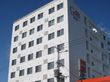 白を基調とした大きなビルのような建物。外壁にはホーム名が書かれ、周りには高い建物はない。
