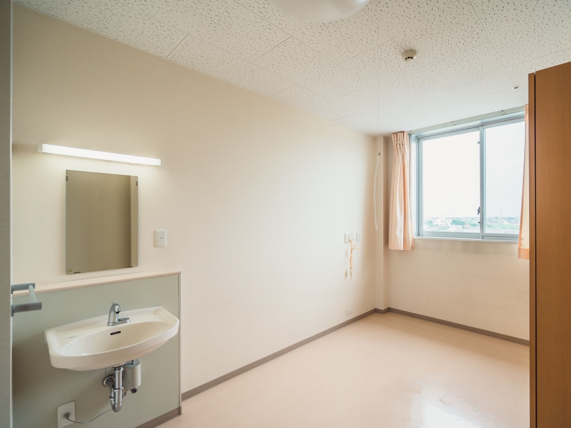 居室ベッドスペース。画像では寝台は置いていないが、その位置の壁にはナースコール用の端子が取り付けてある。