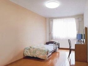 フローリングで、ベッドやテーブルセットが置かれた部屋には大きな窓もある。