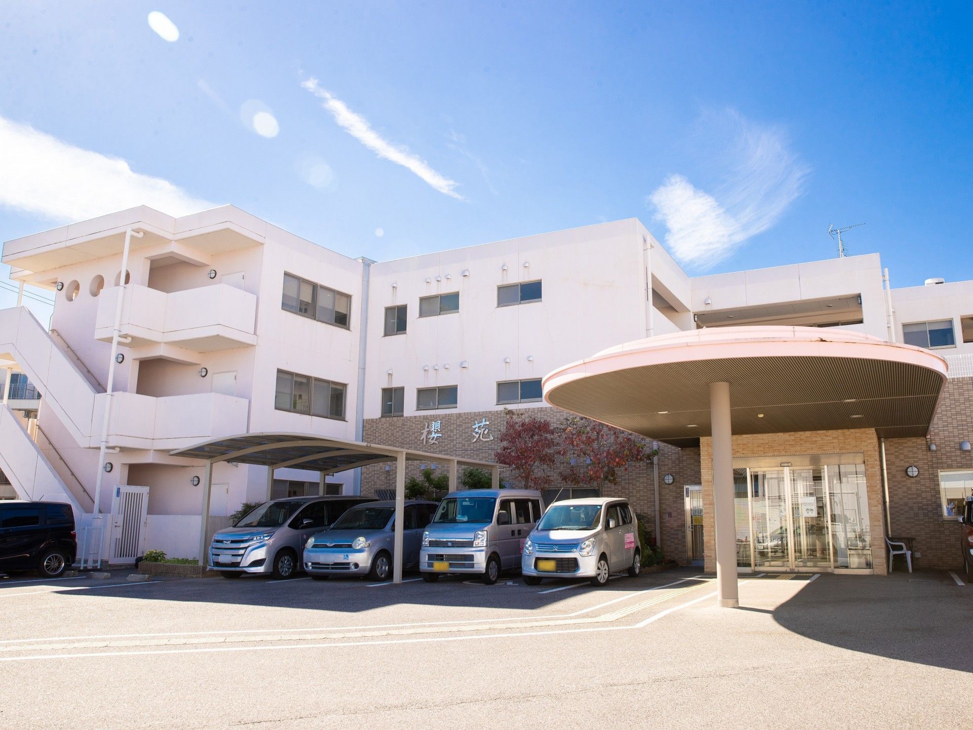 開放感のある敷地に建つ、ピンク色の施設である。駐車場も広く、複数台停めることができる。屋根付きもある。