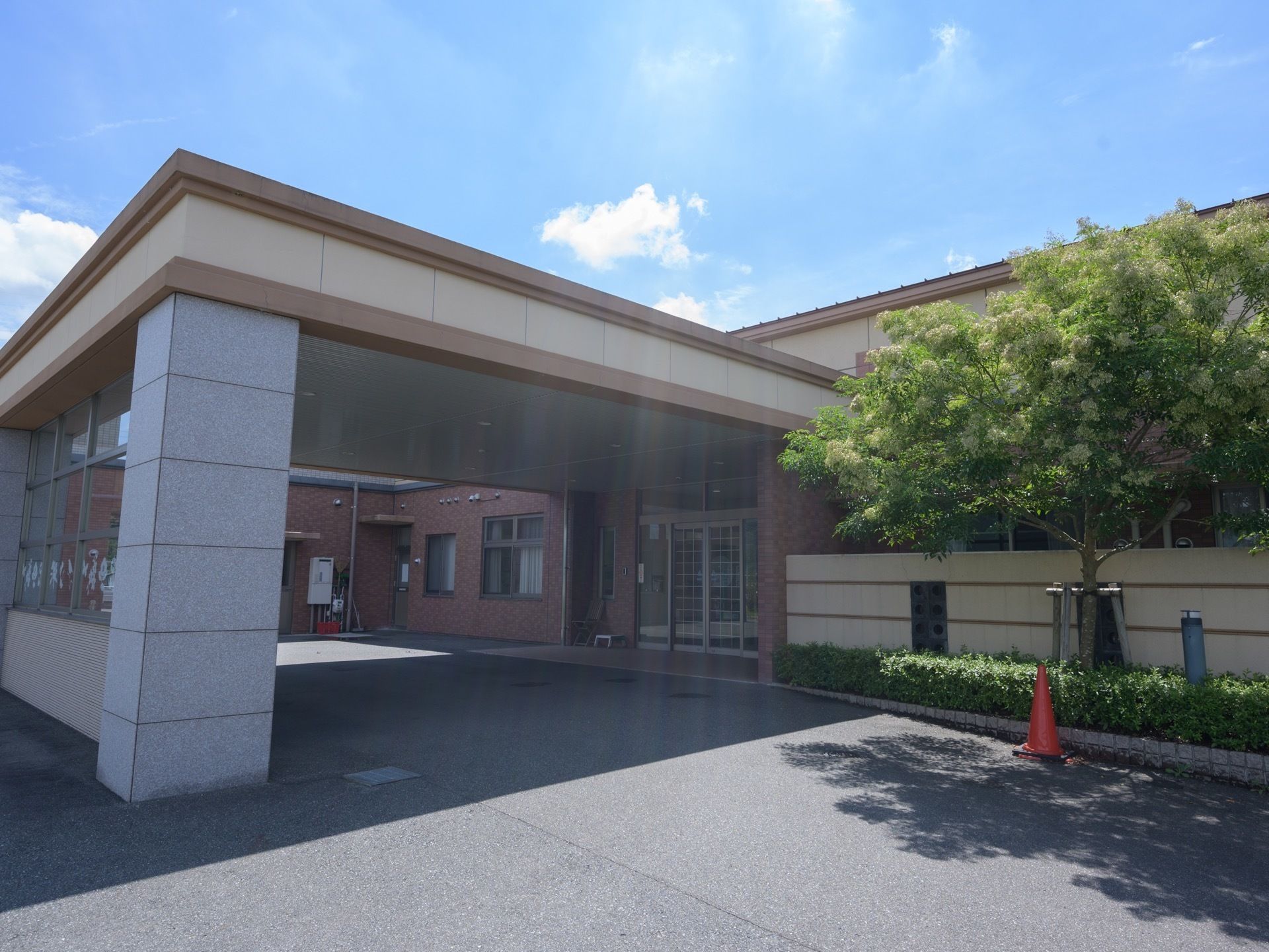 平らに舗装された玄関アプローチがある。入り口の前は屋根があり、車を寄せられる十分なスペースがある。