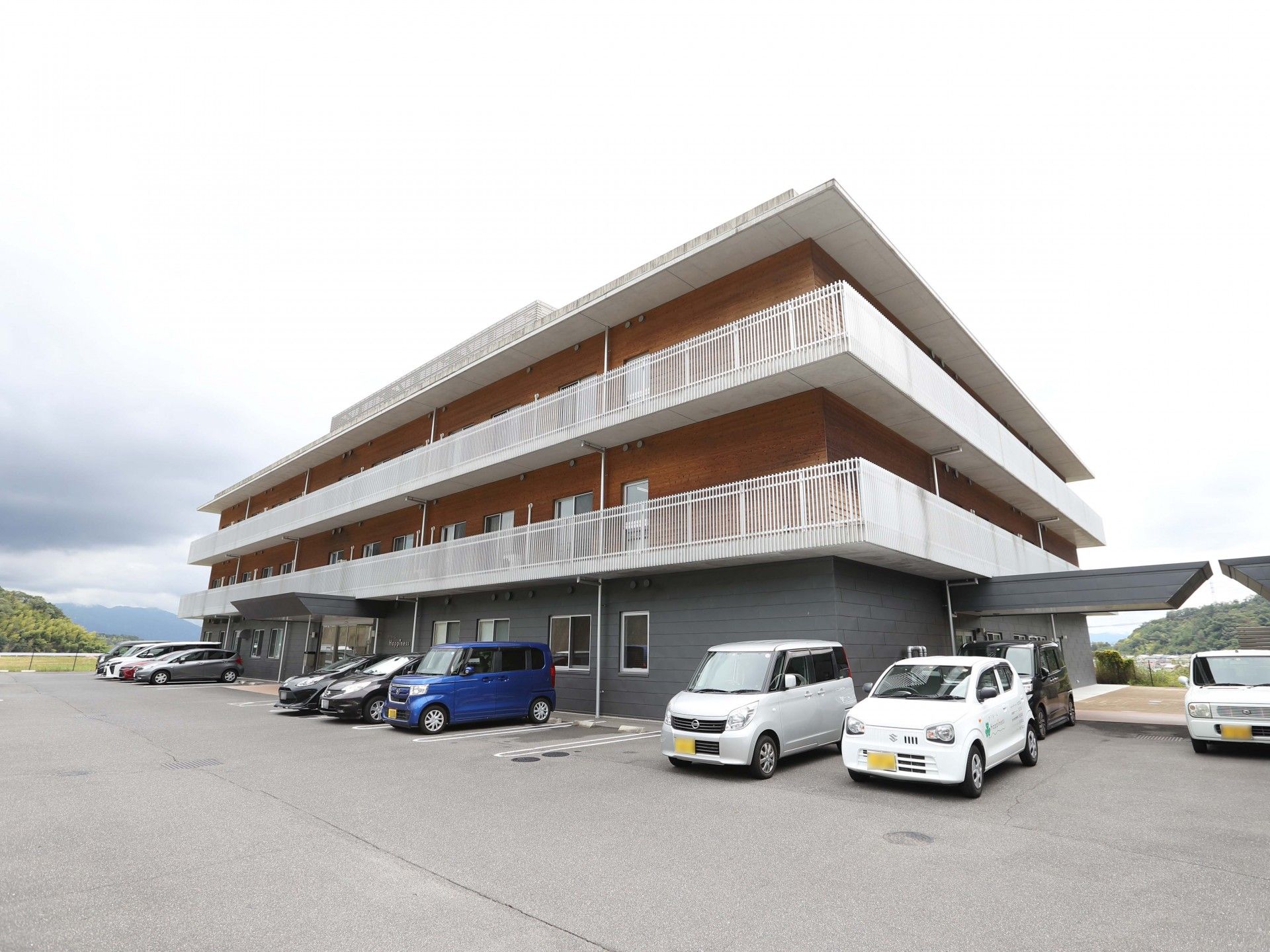茶色とグレーの3階建て