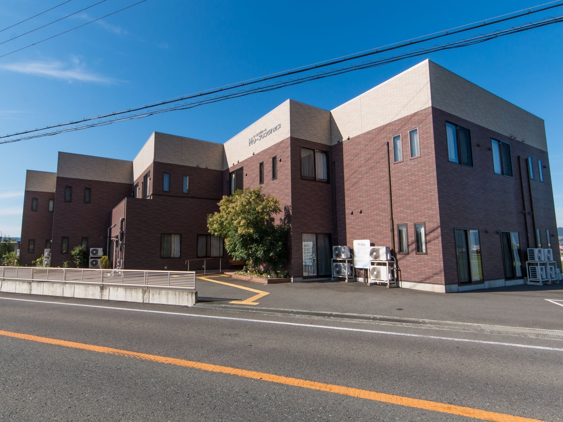 建物の外観は、2階建てで屋根はフラットなボックス型である。壁面は平坦ではなく角の多い多面形で、外壁はあずき色で最上部だけ淡いピンクである。