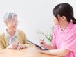 スタッフと高齢者が話している様子。カルテのようなものを書いている場面
