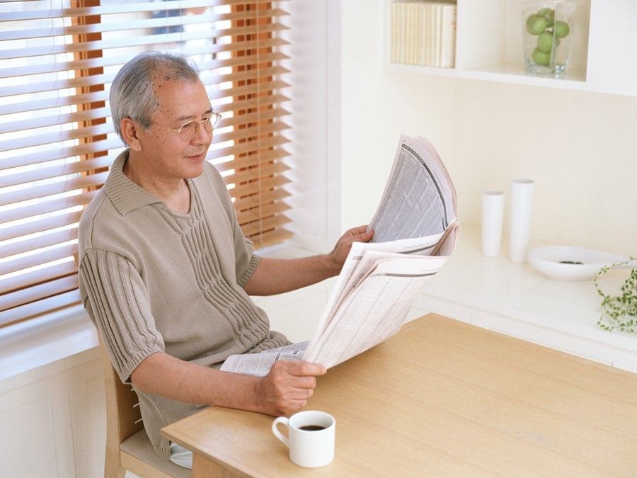 新聞を読む高齢の男性
