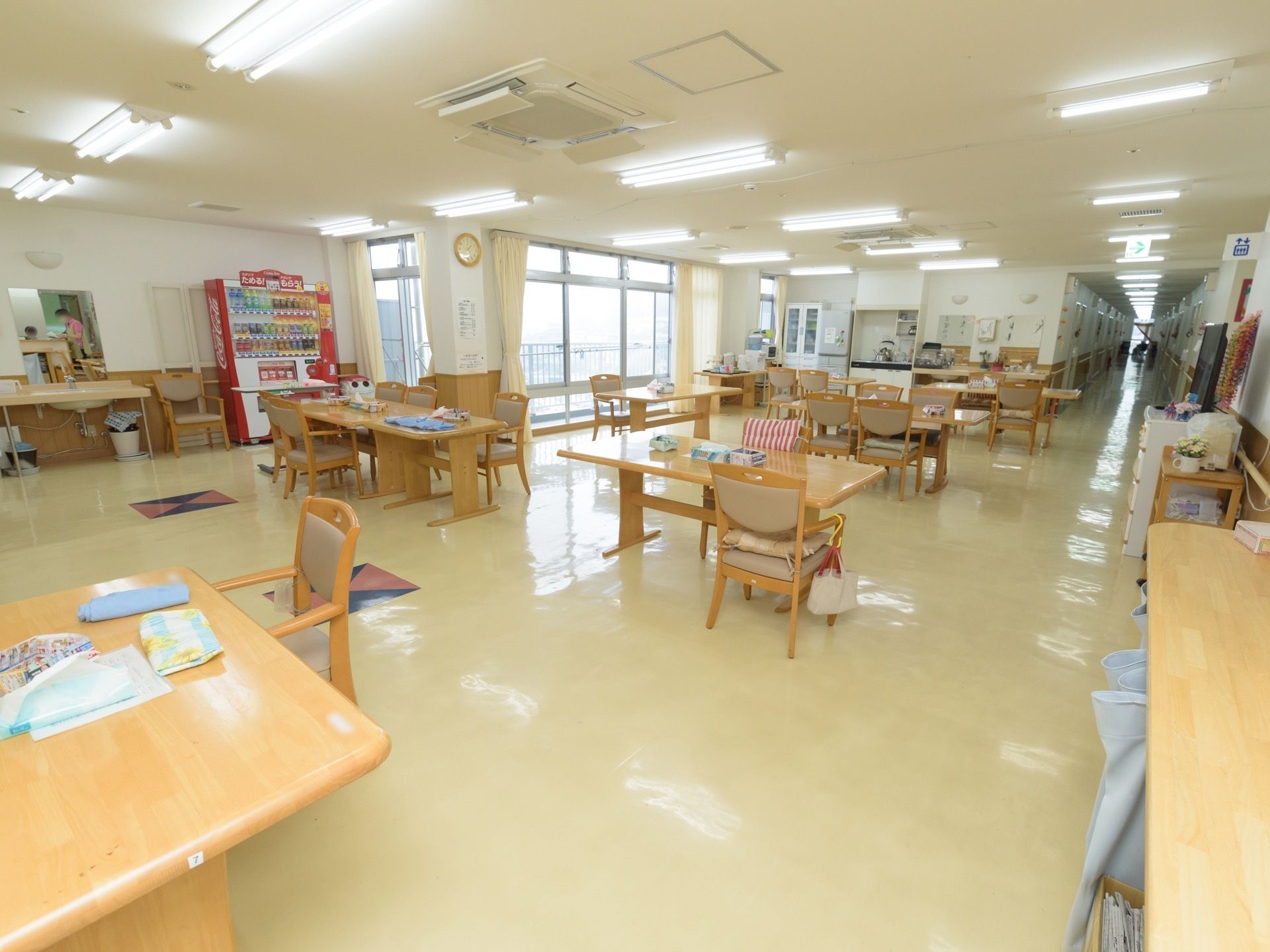壁際には自動販売機があり、その隣には椅子を挟んで洗面台がある。大きな窓が設置されており、そこからベランダに出ることができる。