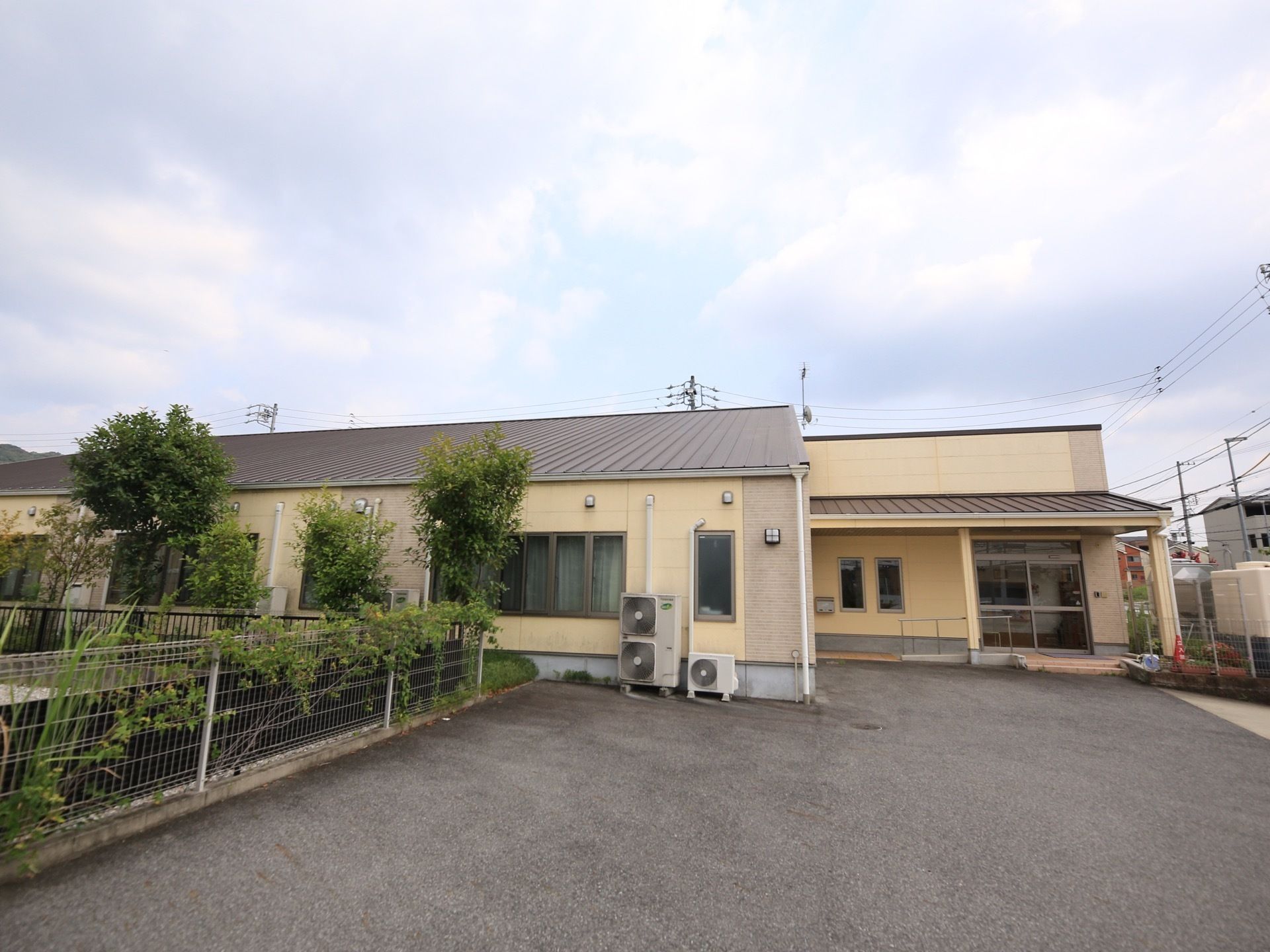 平屋建ての建物である。ホーム前はアスファルトで舗装されており、外壁沿いにはエアコンの室外機がある。