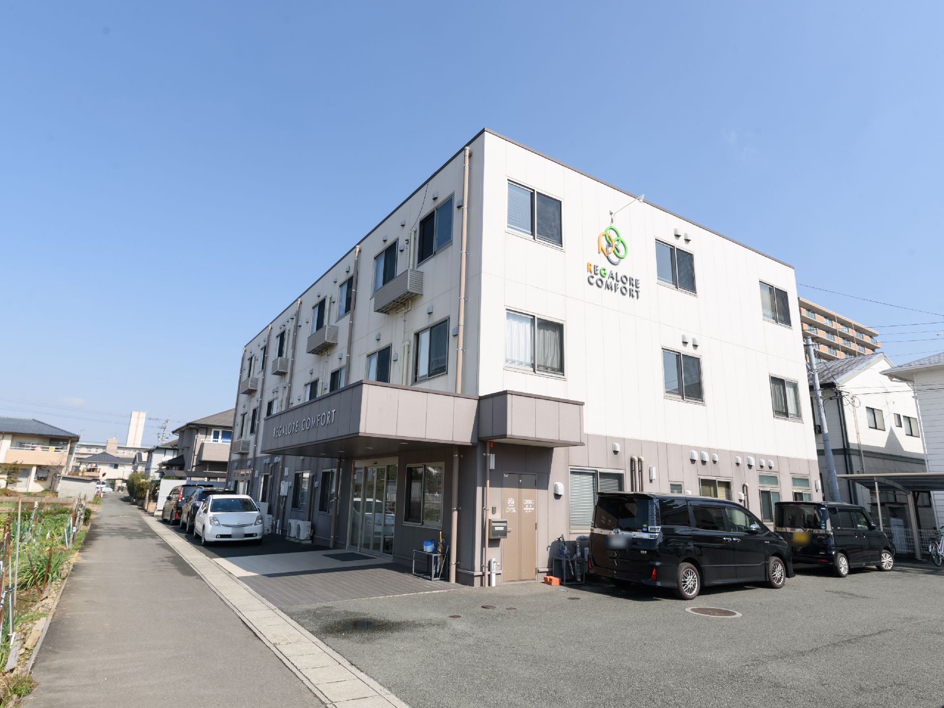 ３階建ての建物で、外壁は１階がブラウン、上が白と２色に分かれている。壁にオレンジと緑を組み合わせたロゴマークと施設名が表示されている。