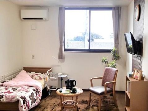エアコンが設置された居室にはベッドやテーブルセット、テレビなどがあり生活館がある。