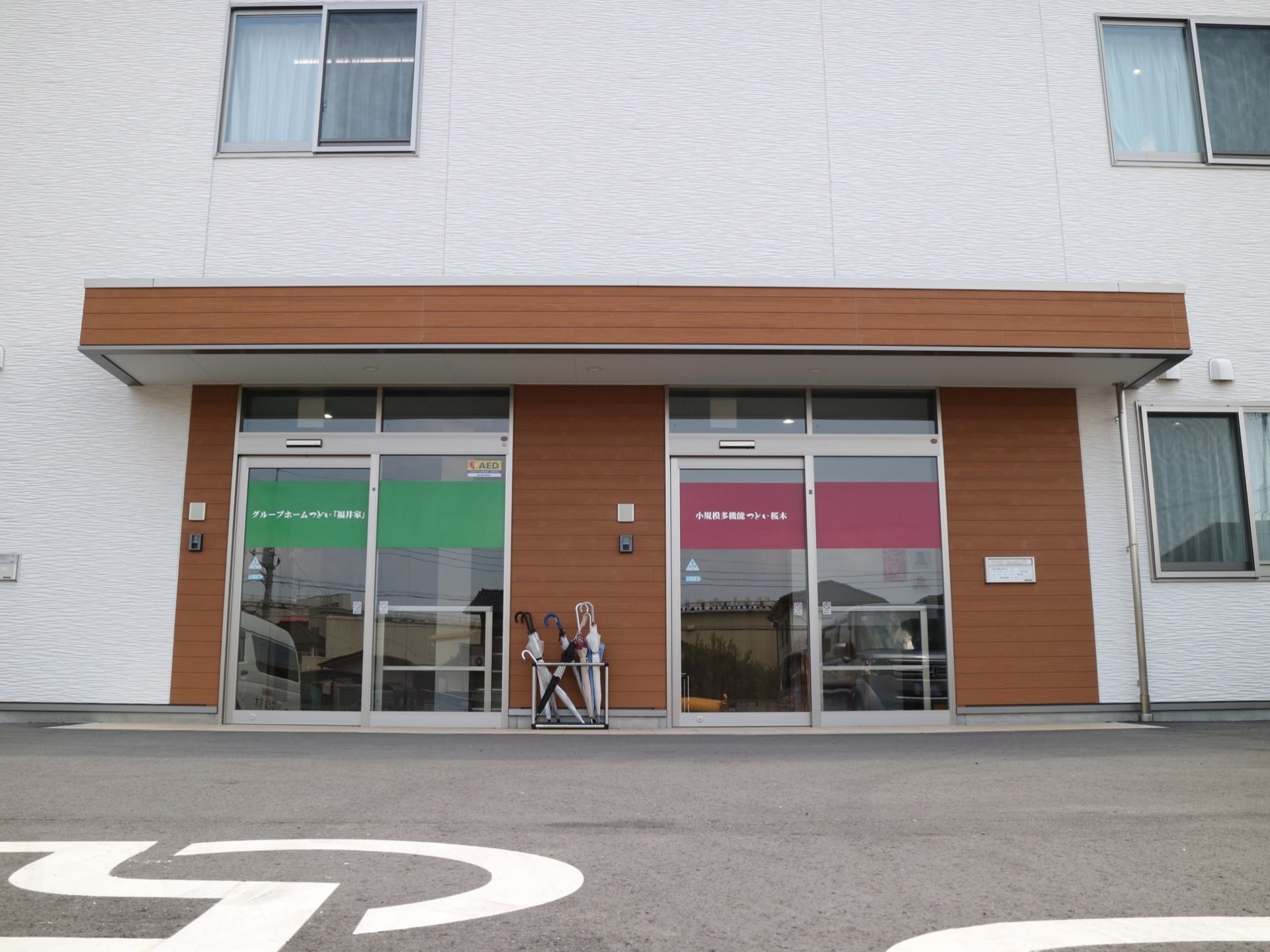 施設入口には、２つのガラス張りの自動ドアが設置されている。各扉の横には、インターホンが取り付けられている。