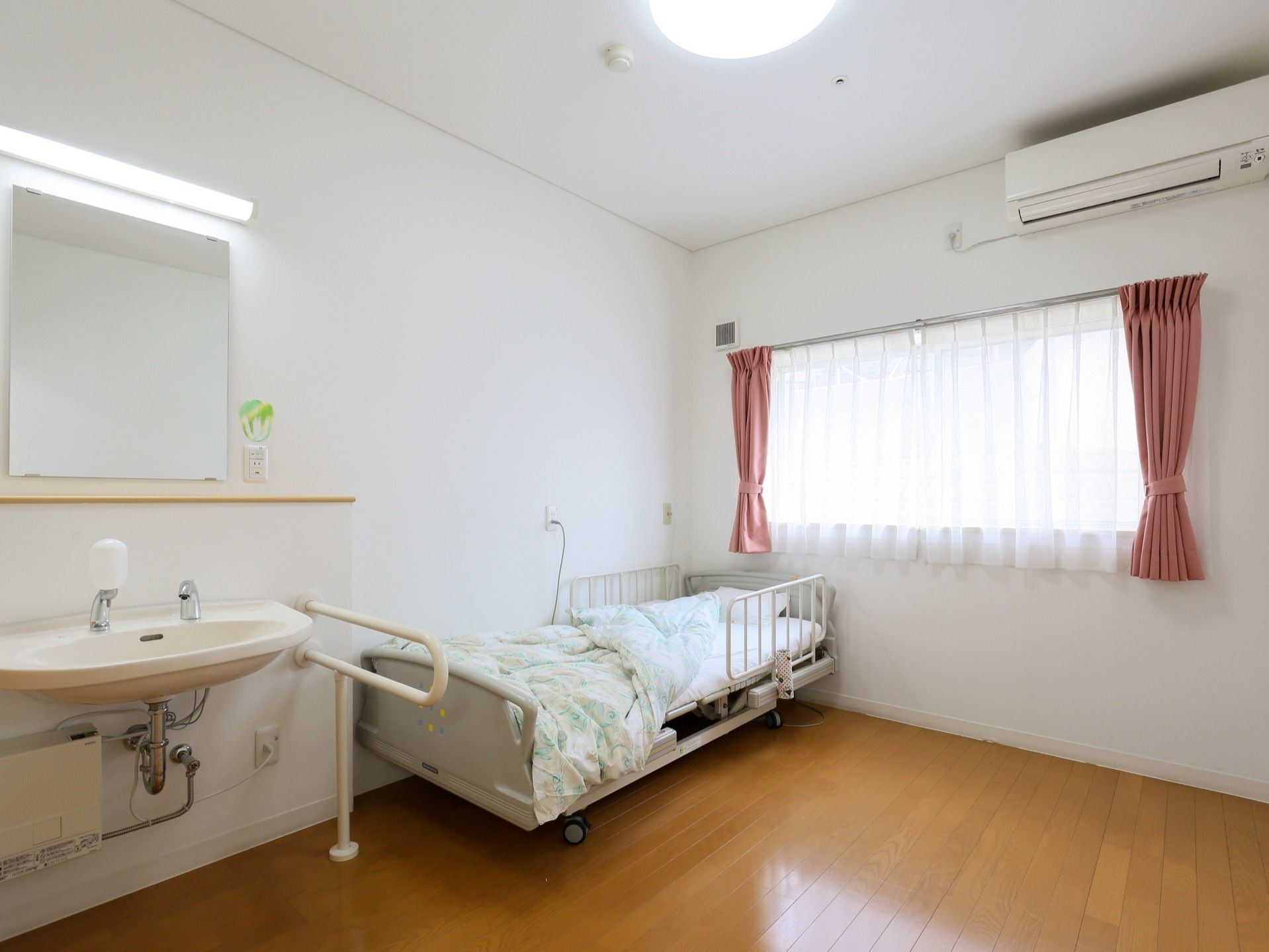 フローリングの洋室の居室である。室内にはエアコンの設備があり、シングルサイズのベッドが1台置かれている。