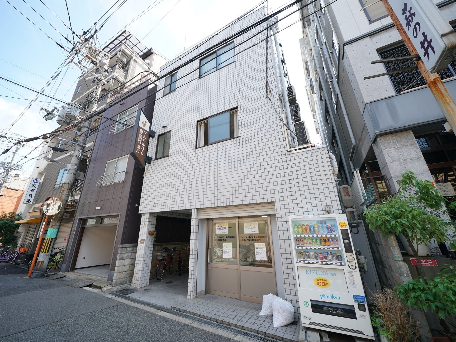 3階建ての建物である。外壁は一面タイル貼りになっている。入り口の近くに自動販売機が1台のみ設置されている。