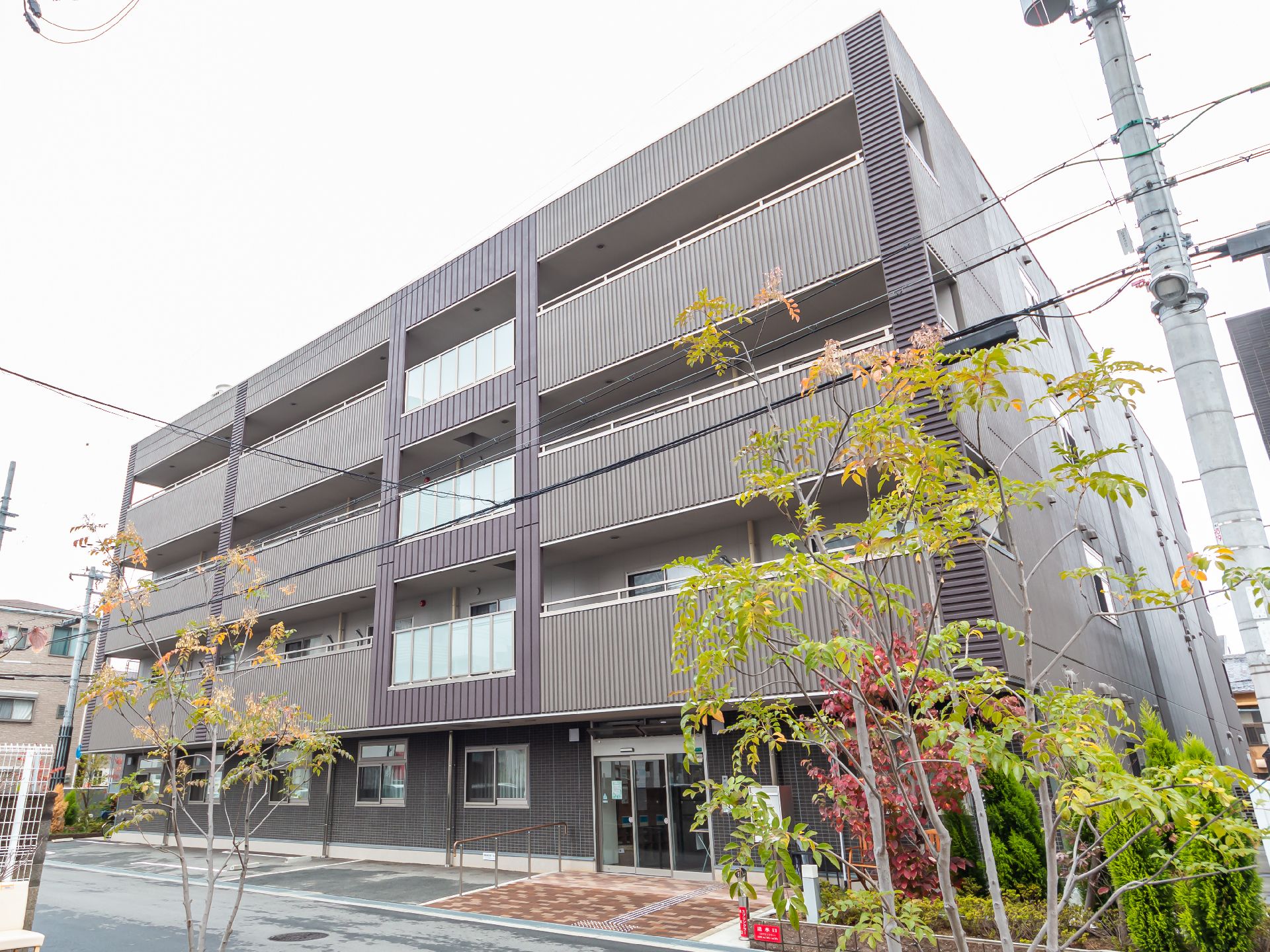 落ち着いた色合いで、マンションのような形状の介護施設の外観