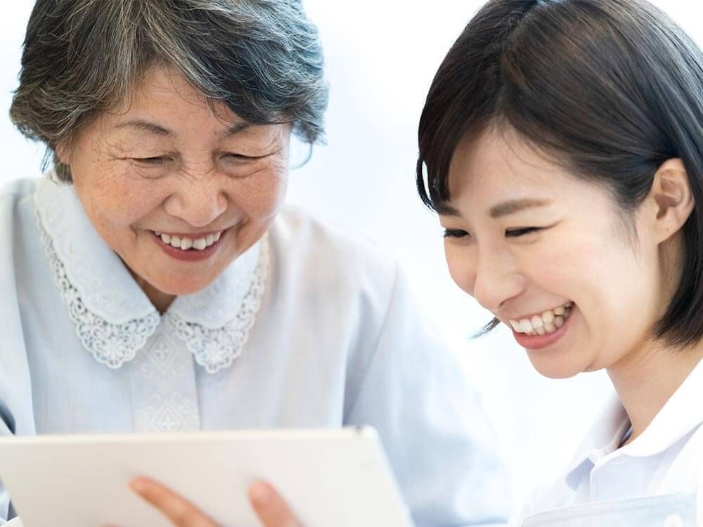 女性ケアマネジャーの話を聞く高齢女性