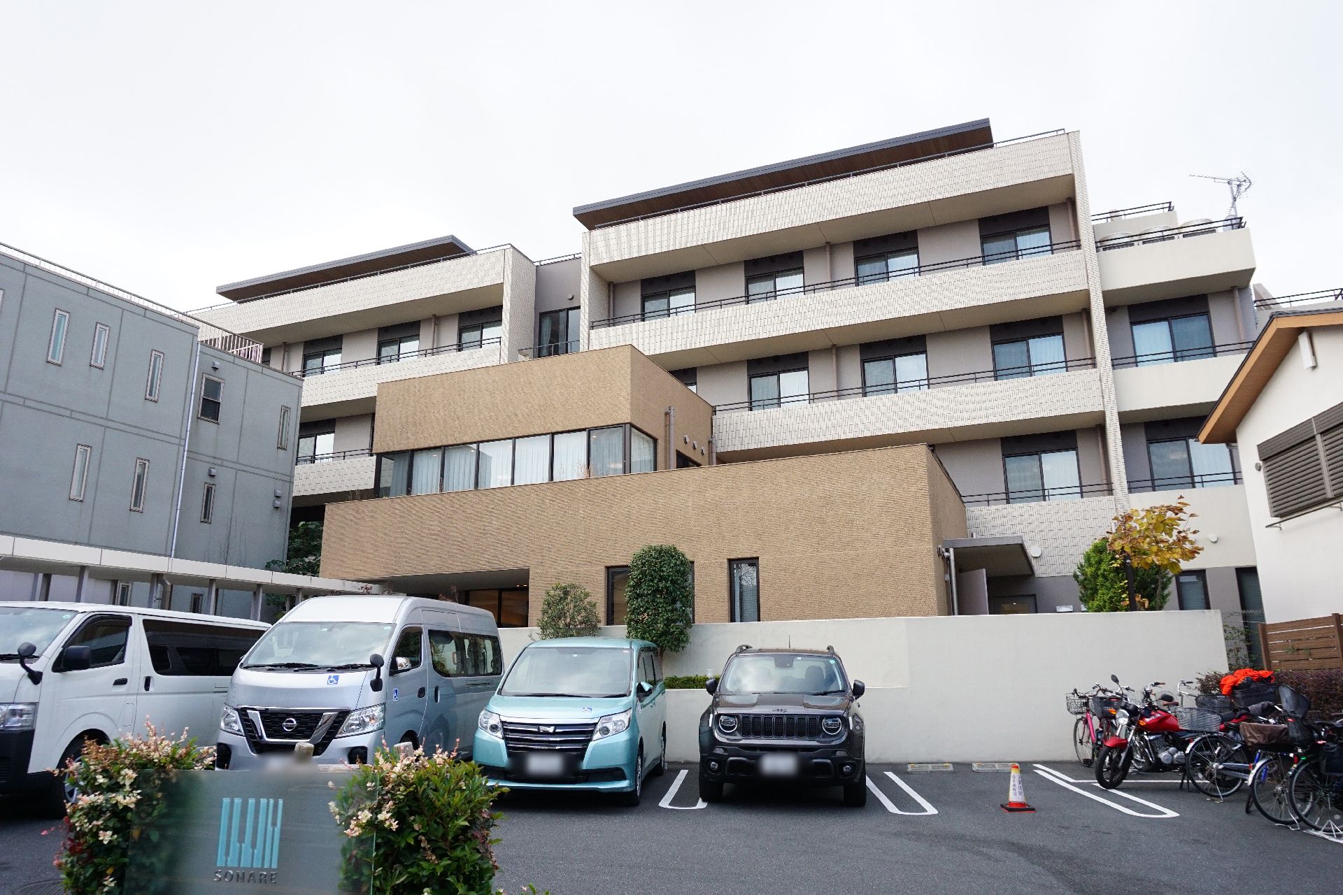 広い駐車場が隣接している、おしゃれな屋根のある介護施設