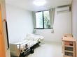 介護用ベッドとエアコン、タンスなどが置いてあるワンルームタイプの部屋の様子