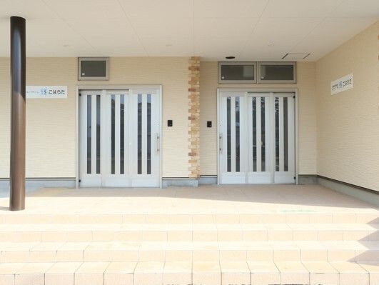 二つのシルバーのドアが合設置されたエントランス。それぞれのドアのそばには事業所名が書かれたプレートがある。
