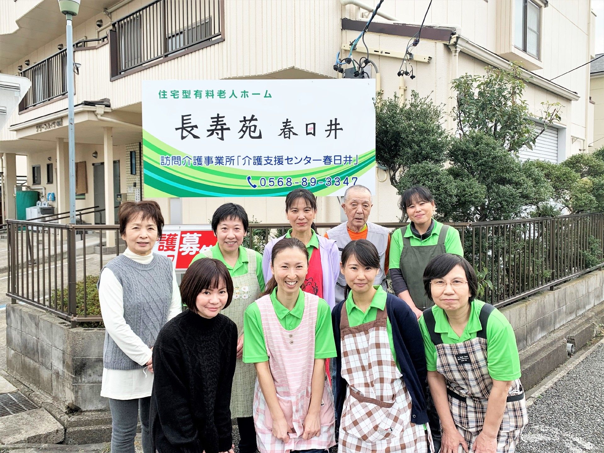 看板の前で写真を撮る介護スタッフ