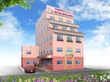 ５階建てのピンクの建物。1番下の階が濃いピンクで玄関には屋根があり、そばに駐車スペースがある。