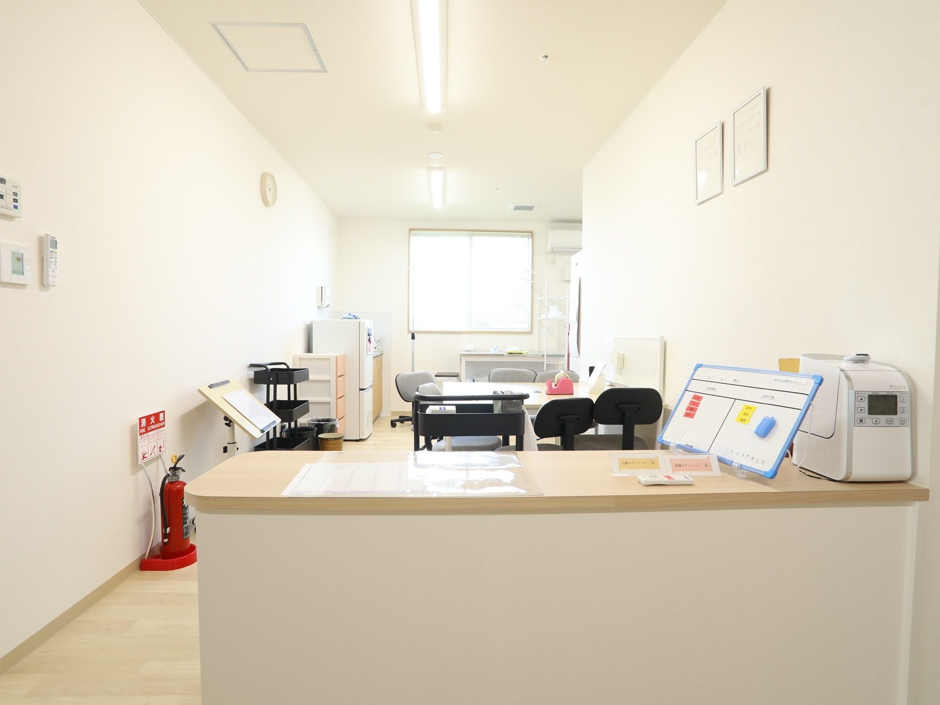 スタッフルームはオープンな造りになっていて、前の方にはカウンターが設置されている。中にはテーブルや椅子、消火器などが置かれている。